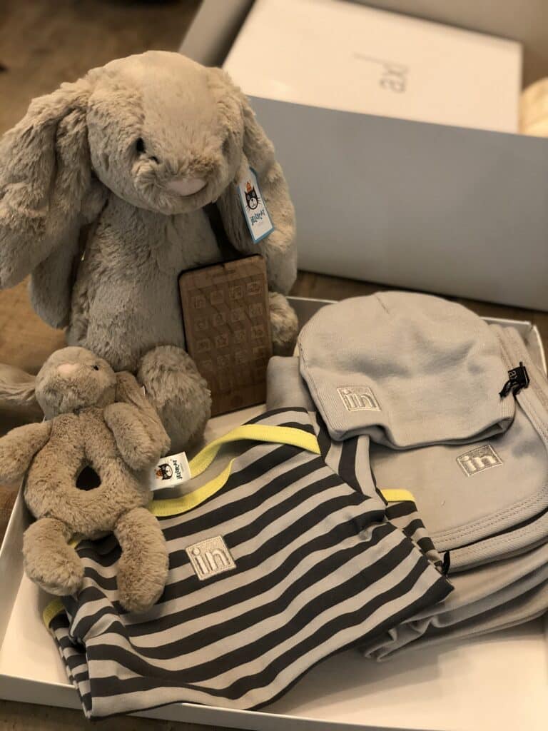 A sweet baby gift including stuffed animals and apparel.