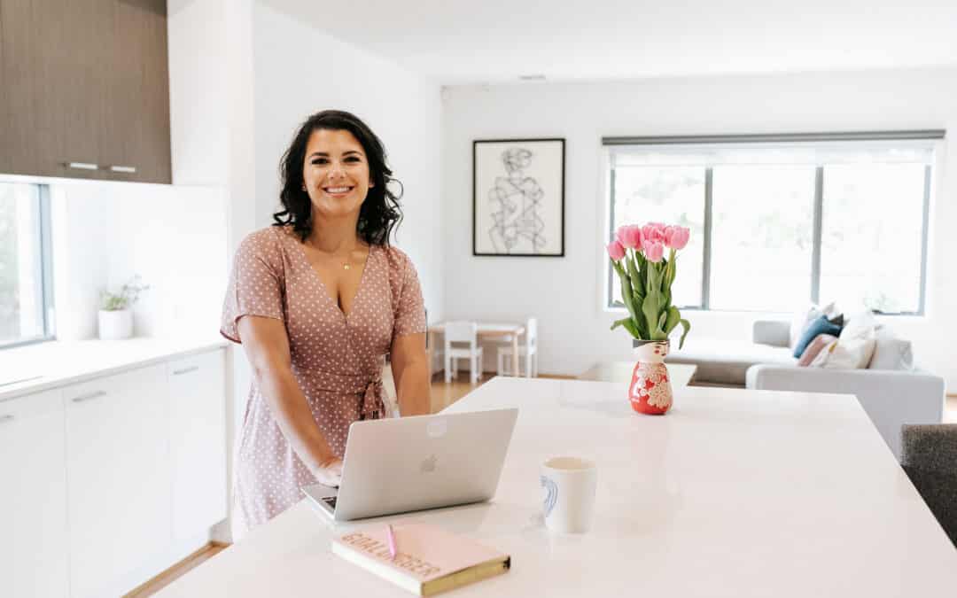 Made to Mother Co founder Andrea Bombino smiles at the camera while working on her laptop.