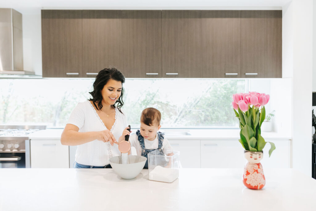 Made to Mother Co's Andrea Bombino bakes with her daughter in her kitchen. Andrea, a motherhood & career coach, suggests that woman rebel against the traditional concept of work-life balance for moms.