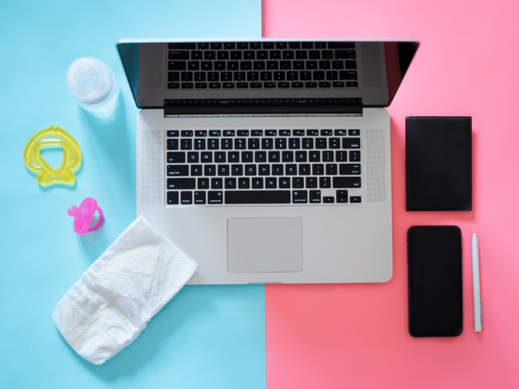 A laptop is shown against a split screen, blue on the left with a bay bottle, pacifier and diapers; pink on the right with a phone and notebook. The image demonstrates work-life balance for moms and the many roles women occupy in their lives.